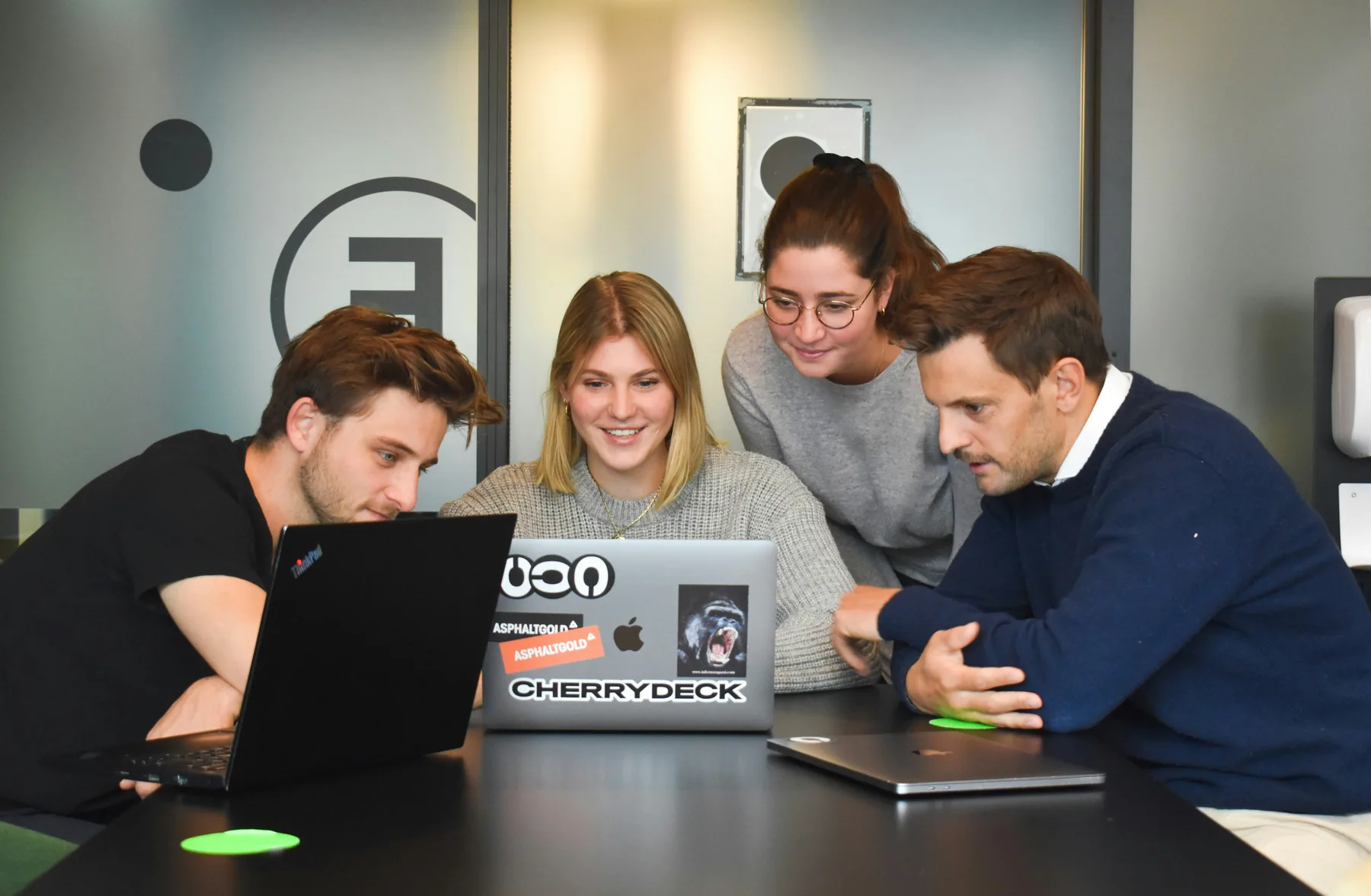 A team collaborating around laptops in a modern office